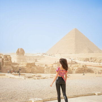 Beautiful Girl standing in front of the Pyramid of Giza and the Sphynx