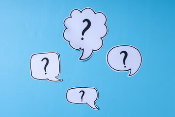 Question marks symbols on speech bubble isolated over blue background. 