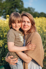 Mother with son in rapeseed field