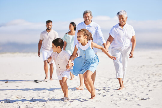Holiday, happy and big family running on the beach for playing and bonding on a weekend trip. Travel, excited and children having fun with their grandparents and parents by the ocean on a vacation.