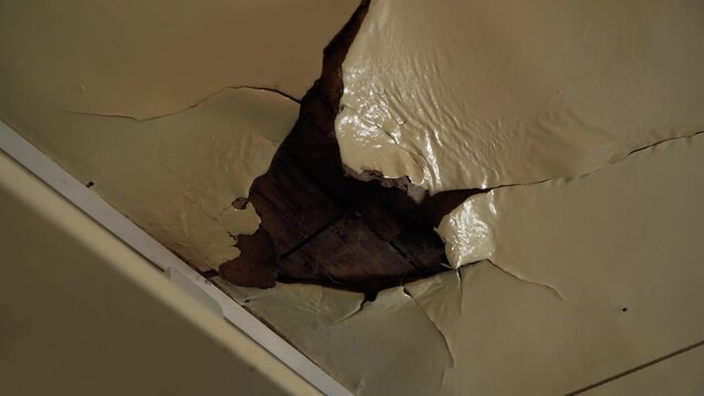 Old ceiling in a wooden house, damaged a huge hole in the roof from rainwater leakage.