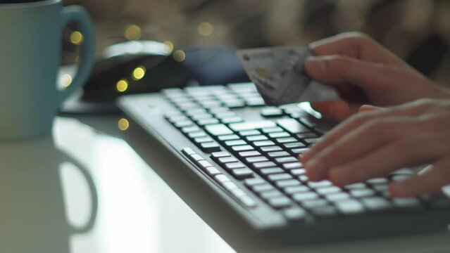 Close up of male hands typing on keyboard. Online purchases with a bank card. Selective focus