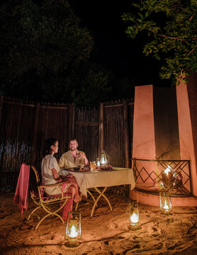 couple men and romantic woman having dinner on a luxury safari, in South Africa l, a luxury safari lodge in the bush of a Game reserve