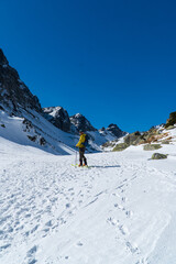Fototapeta na wymiar A skier is walking up the hill. Skitouring in Alps. Sunny weather.