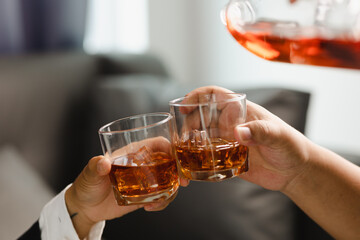 Young man holding whiskey glass in bar or restaurant.