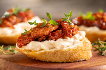 Bruschetta with sun-dried tomatoes, cream cheese and greens.