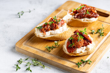 Bruschetta with sun-dried tomatoes, cream cheese and greens.