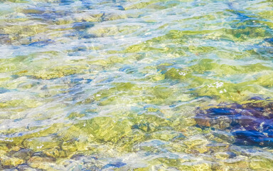 Stones rocks corals turquoise green blue water on beach Mexico.