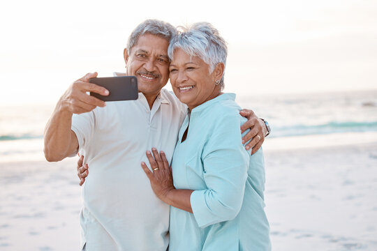 Senior couple, hug and beach for selfie, profile picture or online post together in nature. Happy elderly man and woman smiling on ocean coast for photo, memory or social media vlog in the outdoors