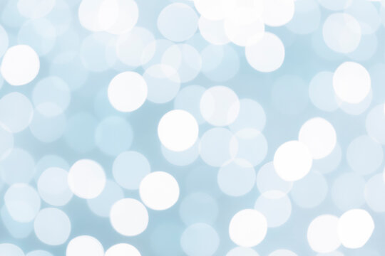 The Light blue glitter festive abstract background with bokeh lights.
