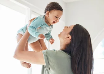 Behang Mother holding laughing baby in home for love, care and quality time together to nurture childhood development. Happy mom, carrying and playing with infant girl kid for support, happiness and fun © peopleimages.com