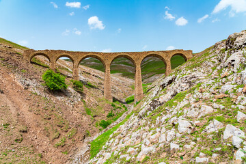 Fototapeta na wymiar An ancient stone bridge in the suburbs of the city of Gadabay, built by the Siemens brothers in 1879 to transport ore to the plant by narrow gauge railway