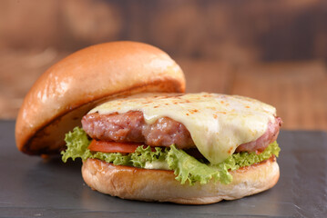 hamburger sandwich with melted cheese lettuce tomato mayonnaise and bread delicious fast food traditional snack