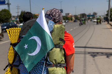 Backpacker walking in Pakistan with a pakistani flag on his backpack