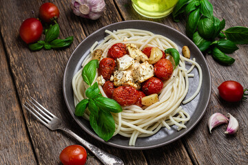 Italian pasta. Spaghetti with baked feta cheese and tomatoes in a bowl