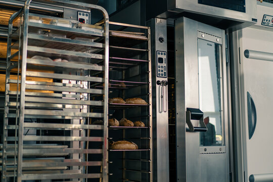 bakery fresh and fragrant bread lies on the shelves of the craft production of flour products near the professional oven - Powered by Adobe