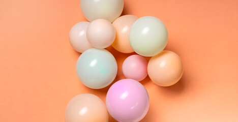 Top view of different sizes of colorful balloons on the orange background
