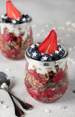 Chocolate granola with strawberries, raspberries and blueberries - a healthy patriotic breakfast for USA Independence Day