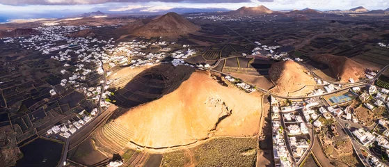 Poster Lanzarote island. Timanfaya national park. aerial drone view of volcano and village Tajaste nearby . Canary islands nature scenery. © Freesurf