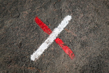 Sinalização de uma cruz de cor branco e vermelho a dar indicação aos caminhantes nos seus...