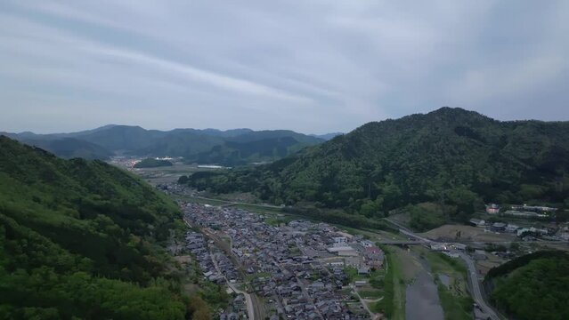 Aerial view of houses in small rural town by mountains at dusk
