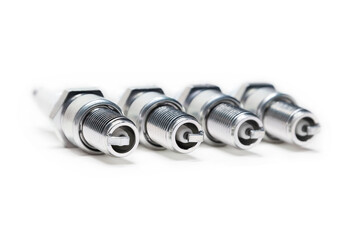 Four spark plugs on a white