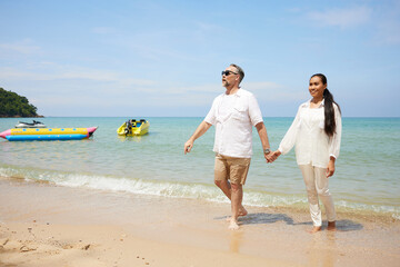 couple walking and looking to sky on the beach