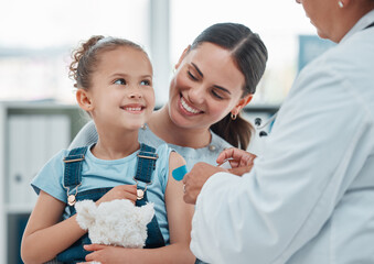 Girl, mom and doctor with vaccine injection, cotton ball and flu shot on arm for disease or covid prevention in hospital. Woman, nurse and child with pediatrician help with bandaid, teddy or health - Powered by Adobe