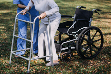 young asian physical therapist working with senior woman on walking with a walker