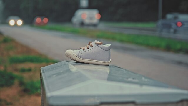 Lost Baby Shoe Left Outdoor On Metal Box on Cold Rainy Day