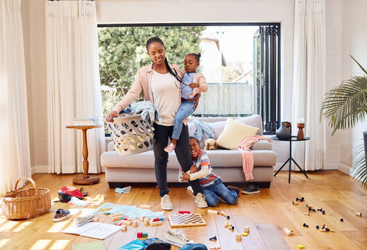 Toys, children and mother with stress, laundry and home with tantrum, messy living room and anxiety. Family, mama and kids with housekeeping, burnout and mental health issue with untidy living room