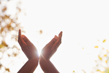 Black woman's hands held up in prayer, sunbeam from heaven, white background