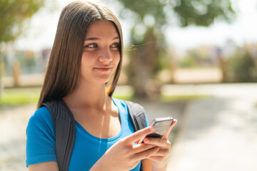 Teenager girl at outdoors using mobile phone