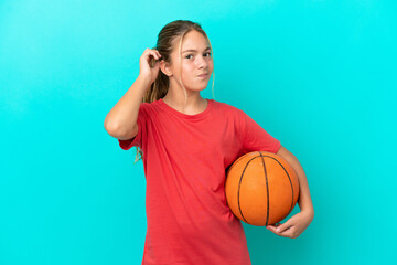 Little caucasian girl playing basketball isolated on blue background having doubts