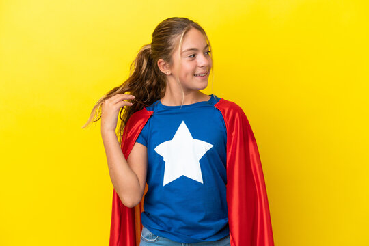 Super Hero little girl isolated on yellow background thinking an idea