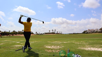Professional golfer with one arm hitting the ball on the golf course. Concept of willpower of...