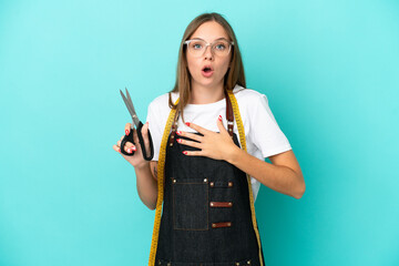 Young Lithuanian seamstress woman isolated on blue background surprised and shocked while looking...