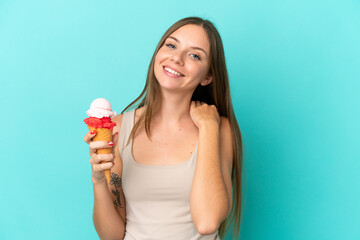 Young Lithuanian woman with cornet ice cream isolated on blue background laughing