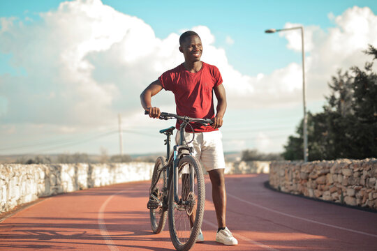 young man with a bicycle on a running track