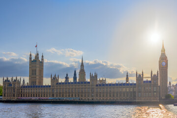 Houses of Parliament and Big Ben in London at sunset with the sun backlit behind Parliament