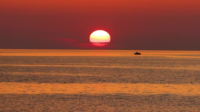 Tramonto sul mare con sagoma di pescatore e barca