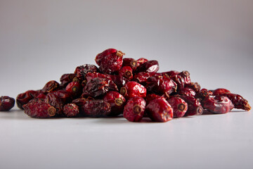 Close-up of a bunch of delicious bright red rosehips on a gray background. Useful vitamin superfood...