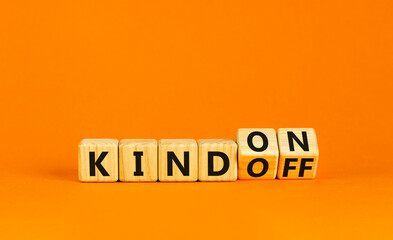 Kind on or off symbol. Businessman turns wooden cubes and changes word Kind off to Kind on. Beautiful orange table orange background. Business and kind on or off concept. Copy space.