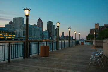 Obraz premium Promenade along the East River with view of Manhattan at blue hour, on Roosevelt Island, New York City