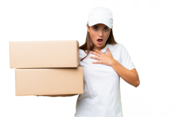 Delivery caucasian woman holding boxes isolated on green chroma background surprised and shocked while looking right