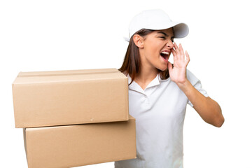 Delivery caucasian woman holding boxes isolated on green chroma background shouting with mouth wide open to the side