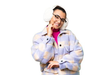 Young woman wearing winter muffs over isolated chroma key background with glasses and happy