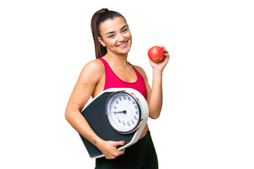 Young beauty woman over isolated chroma key background with weighing machine and with an apple