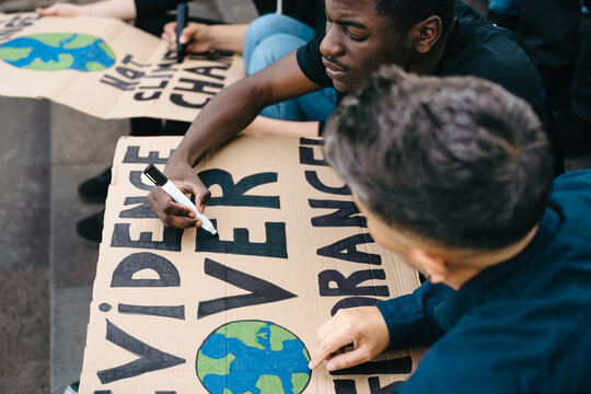 Multiracial activists preparing protest signs against climate change - Global warming concept