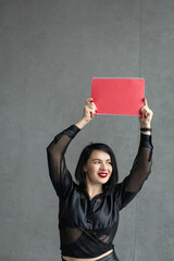 A woman in a blouse and red lips holds up a sign